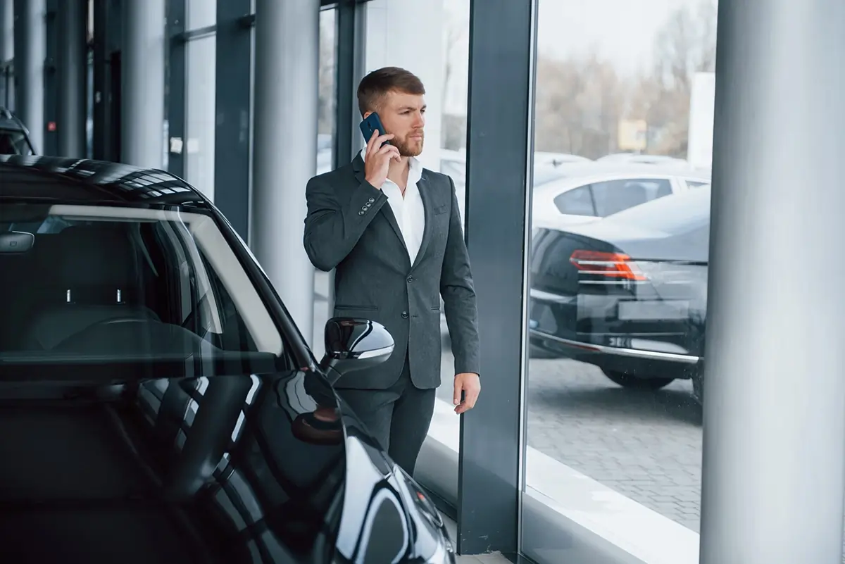 Închirieri auto premium – flotă business modernă și fiabilă client business langa masina premium in showroom inchiriere auto confort si siguranta